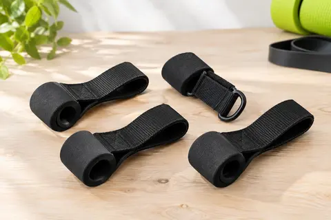 Quatre ancrages de porte noirs pour bandes de résistance, avec sangles en nylon et butées en mousse.